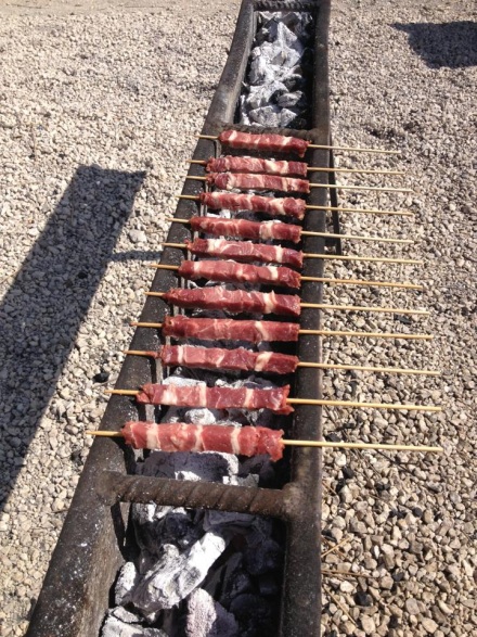 Arrosticini roasting over coals